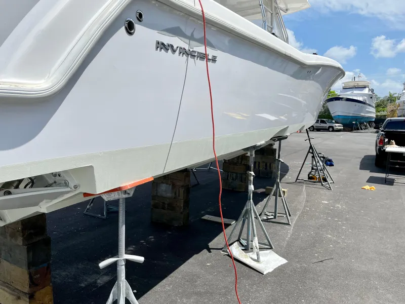 Slide: The Image of 2013 Invincible 42 Open Fisherman boat on stands, outdoor setting. - 6