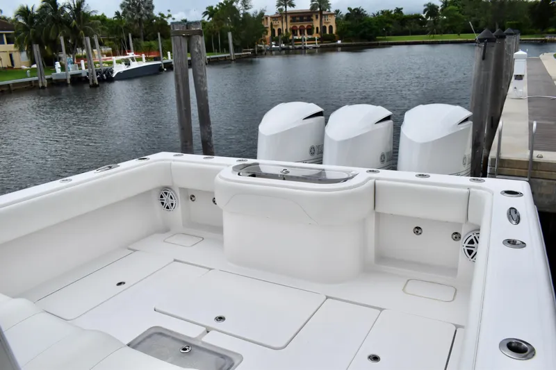 Slide: The Image of 2013 Invincible 42 Open Fisherman boat with triple engines docked by a serene waterfront. - 7