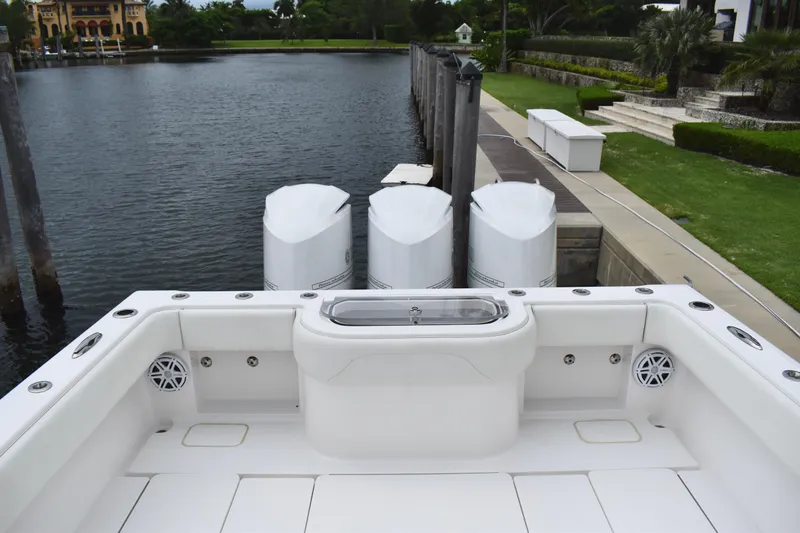 Slide: The Image of 2013 Invincible 42 Open Fisherman boat with triple engines docked by a serene waterfront. - 8