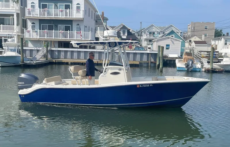 Slide: The Image of 2015 NauticStar 2200XS Offshore boat docked near waterfront homes. - 1