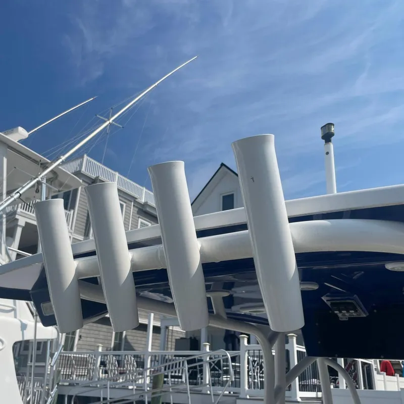 Slide: The Image of 2015 NauticStar 2200XS Offshore boat with rod holders, docked under a clear blue sky. - 19