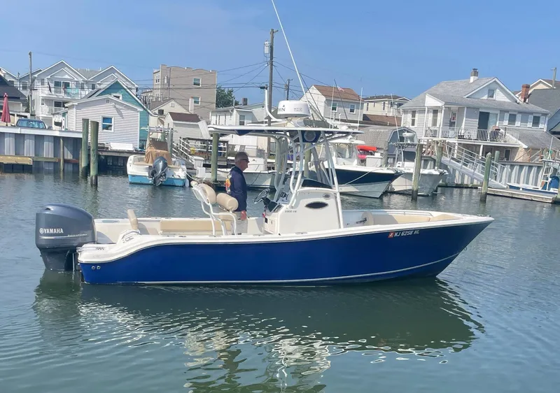 Slide: The Image of 2015 NauticStar 2200XS Offshore boat in a marina, featuring a Yamaha outboard motor. - 28