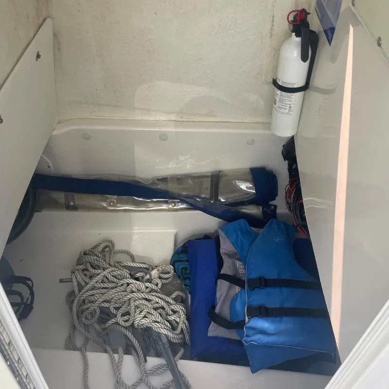 Slide: The Image of Storage compartment of 2015 NauticStar 2200XS Offshore with ropes, life jackets, and fire extinguisher. - 7