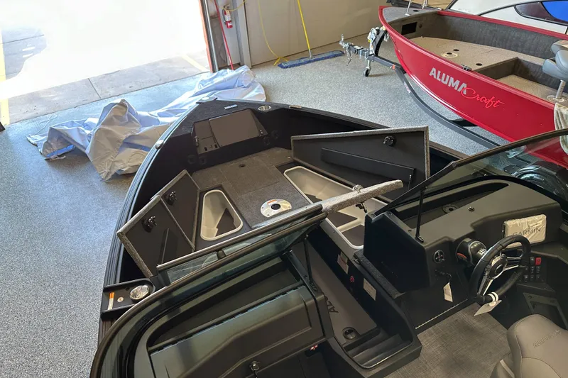 Slide: The Image of 2026 Alumacraft Competitor 185X Sport interior with seating and storage compartments. - 13