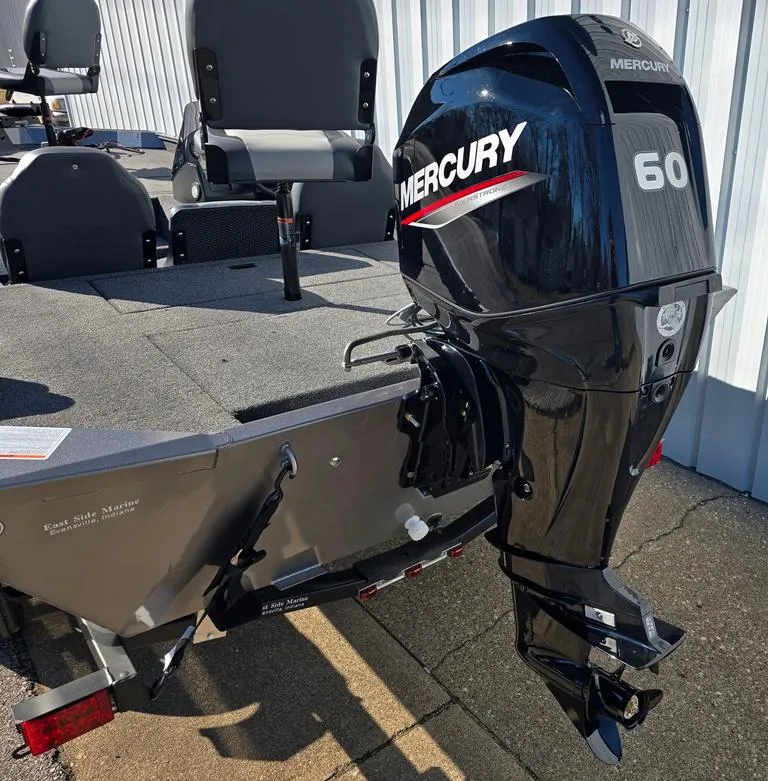 Slide: The Image of 2025 Lowe 1860 Legacy boat with Mercury 60 outboard motor, docked outdoors. - 6