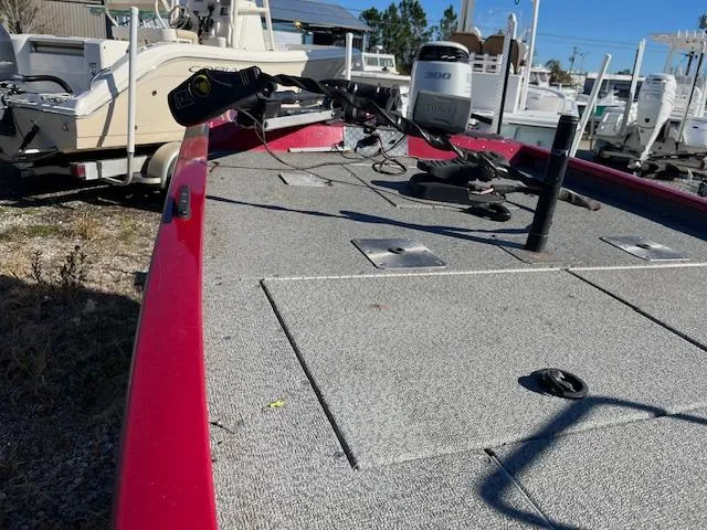 Slide: The Image of 2014 G3 176 EAGLE boat deck with motor, red trim, parked outdoors. - 2