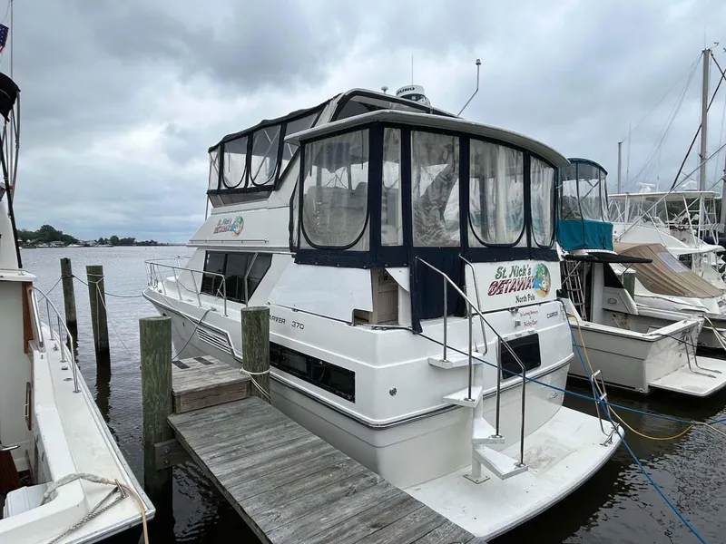 Slide: The Image of 1995 Carver 370 Aft Cabin yacht docked at marina under cloudy skies. - 1