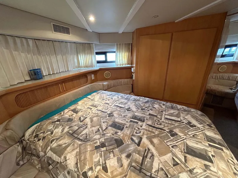 Slide: The Image of 1995 Carver 370 Aft Cabin interior with bed, wood paneling, and curtains. - 10