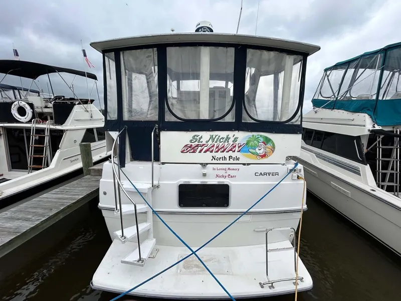 Slide: The Image of 1995 Carver 370 Aft Cabin boat docked, featuring "St. Nick's Getaway" signage. - 2