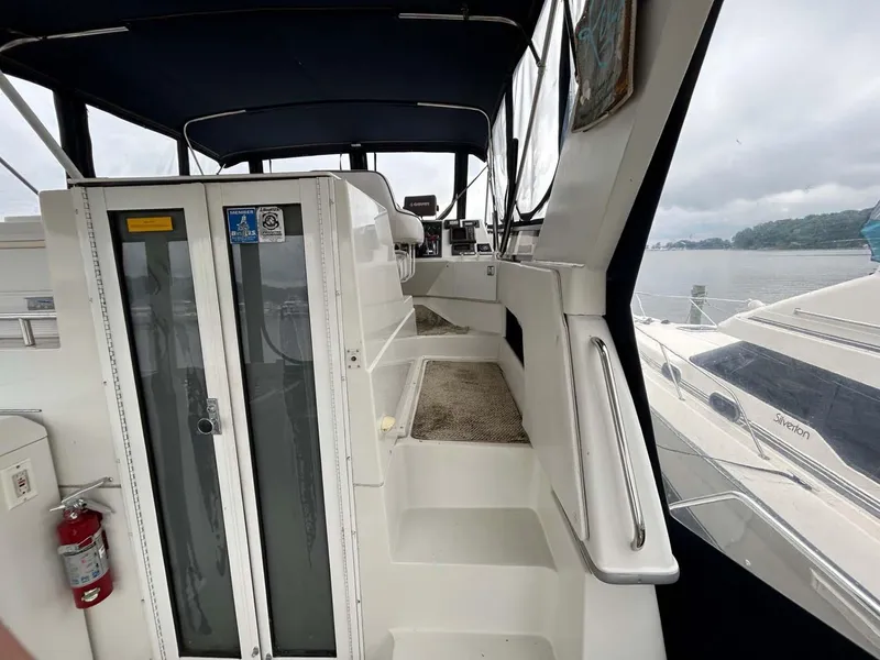 Slide: The Image of 1995 Carver 370 Aft Cabin interior with steps, glass doors, and marina view. - 23
