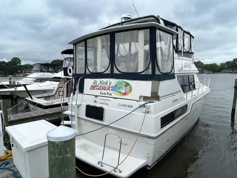 Slide: The Image of 1995 Carver 370 Aft Cabin yacht docked at marina under cloudy skies. - 3