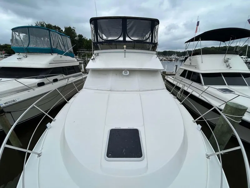 Slide: The Image of 1995 Carver 370 Aft Cabin yacht docked between two boats. - 30