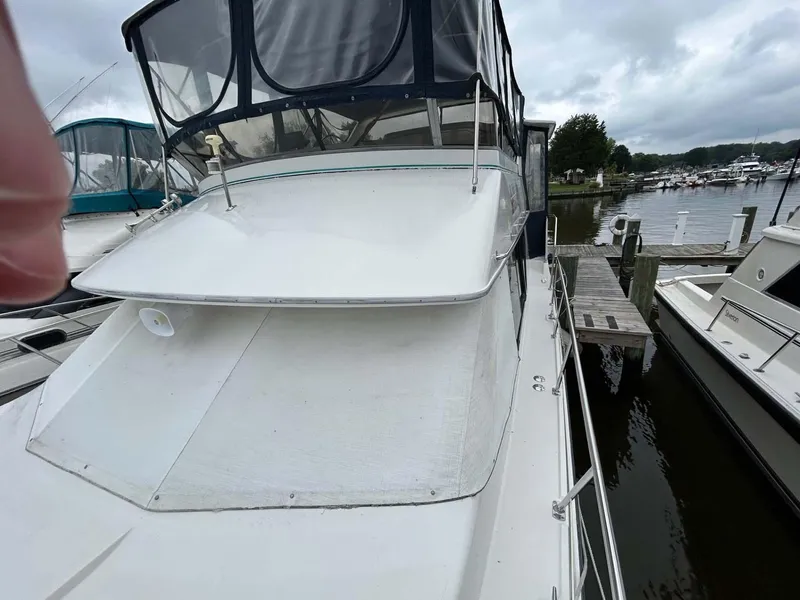 Slide: The Image of 1995 Carver 370 Aft Cabin yacht docked at a marina under cloudy skies. - 32