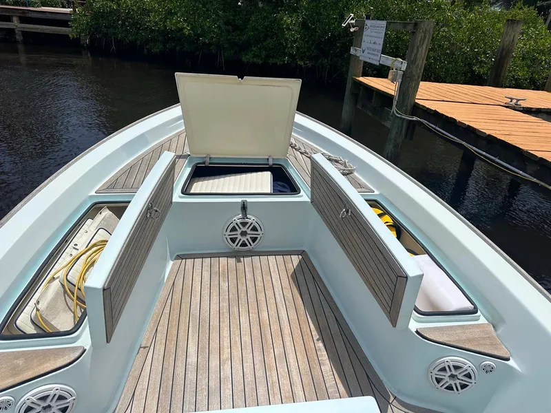 Slide: The Image of 2004 Pathfinder 2400 V boat with open storage compartments, docked near wooden pier. - 4