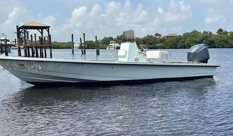 Slide: The Image of 2004 Pathfinder 2400 V boat on calm water, dock and trees in background. - 9