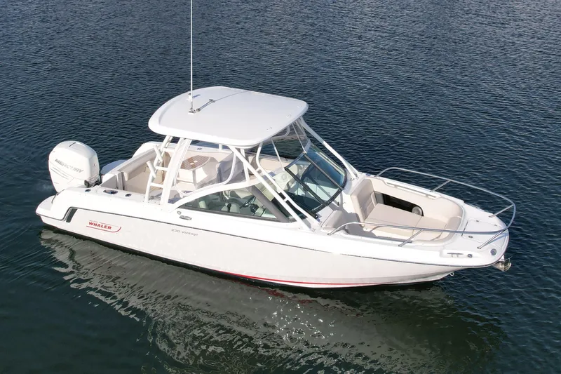 Slide: The Image of 2018 Boston Whaler 230 Vantage boat on calm water, featuring sleek design and spacious seating. - 1