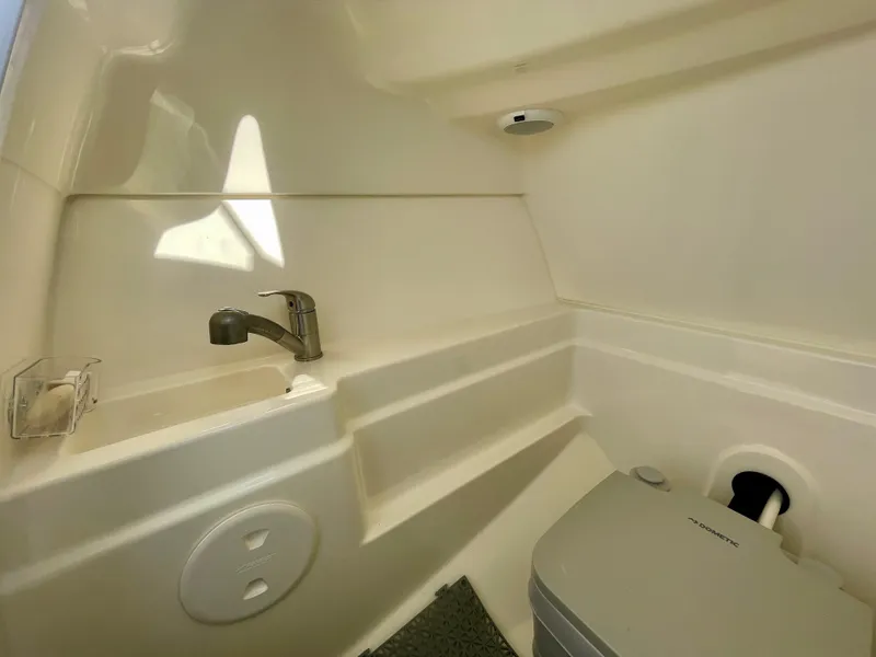 Slide: The Image of Interior of 2018 Boston Whaler 230 Vantage boat, featuring a compact sink and toilet. - 10