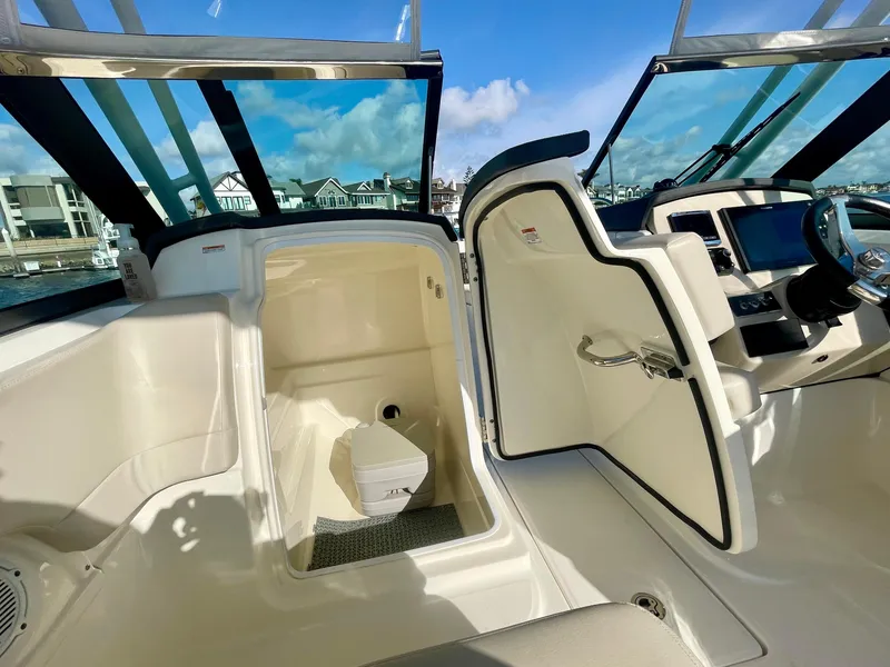 Slide: The Image of 2018 Boston Whaler 230 Vantage boat interior with open storage compartment and helm. - 11