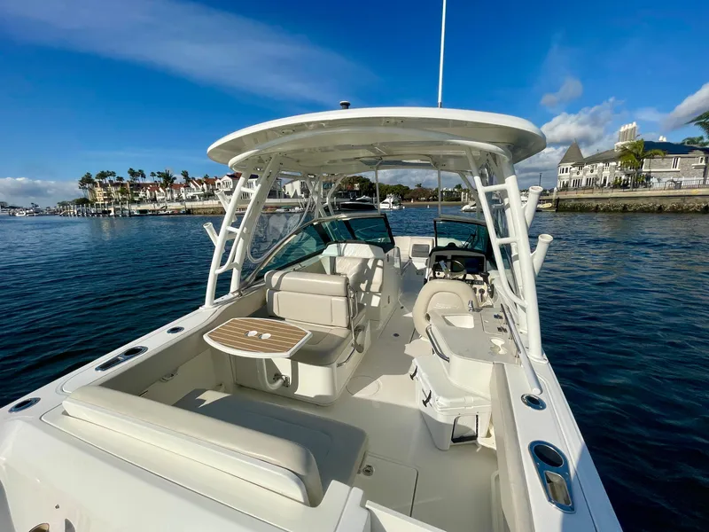 Slide: The Image of 2018 Boston Whaler 230 Vantage boat on water, featuring spacious seating and sleek design. - 16