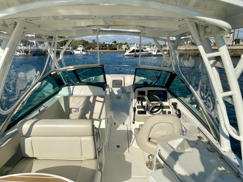 Slide: The Image of 2018 Boston Whaler 230 Vantage boat interior with seating and steering console on water. - 17