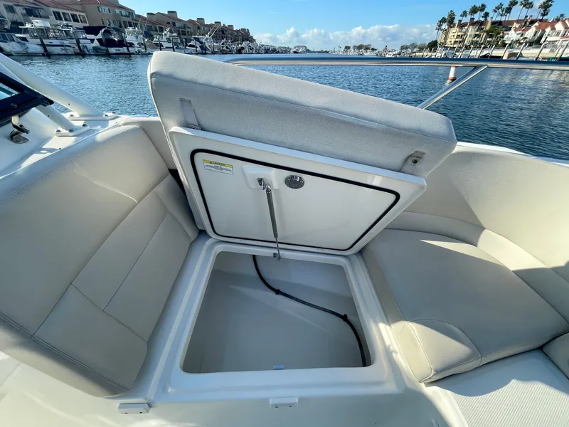 Slide: The Image of 2018 Boston Whaler 230 Vantage boat with open storage compartment, dockside view. - 31