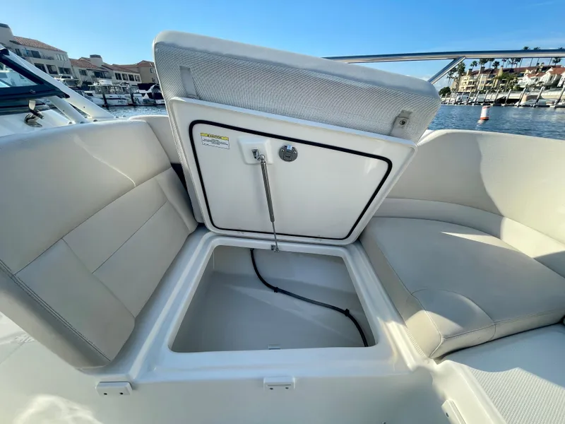Slide: The Image of 2018 Boston Whaler 230 Vantage boat with open storage compartment, dockside view. - 32