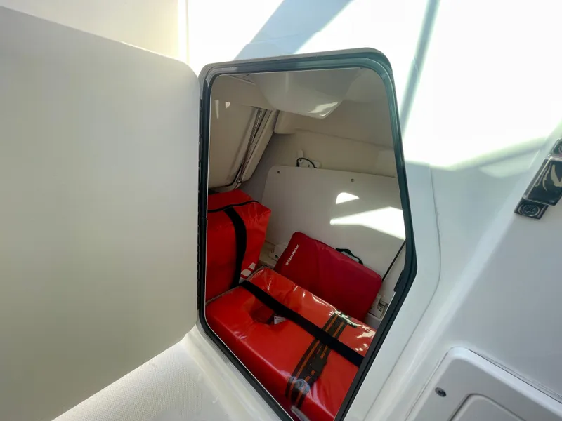 Slide: The Image of 2018 Boston Whaler 230 Vantage storage compartment with red life jackets. - 42
