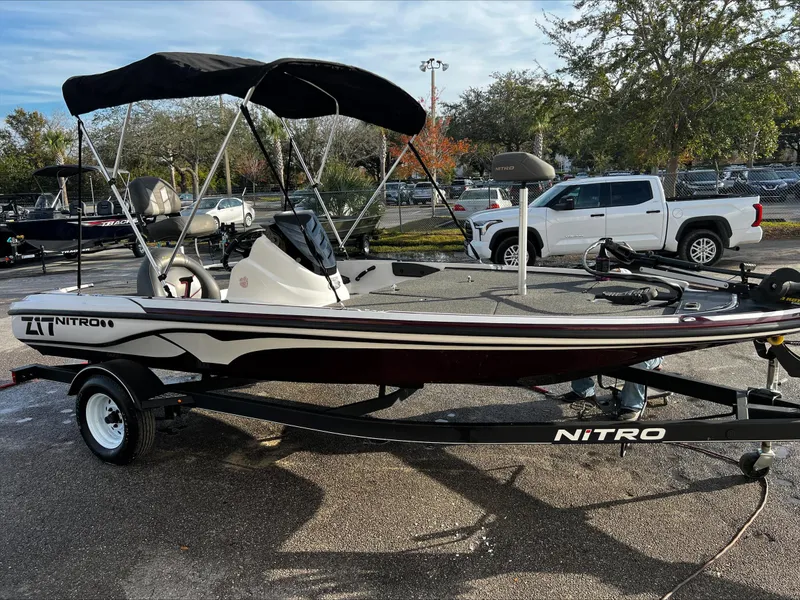 Slide: The Image of 2019 Nitro Z17 boat on trailer, parked outdoors with canopy and trees in background. - 0