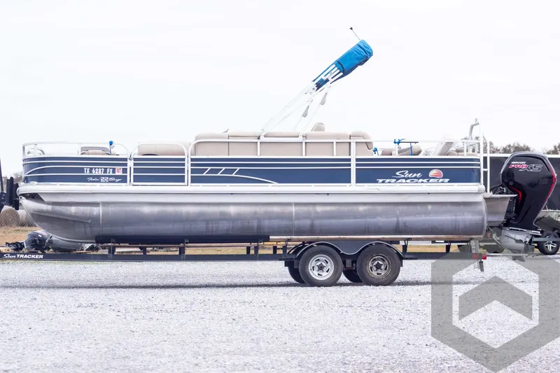 Slide: The Image of 2020 Sun Tracker Fishin' Barge 22 DLX pontoon boat on a trailer, side view. - 11
