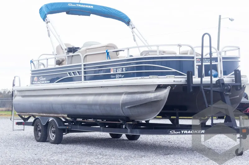 Slide: The Image of 2020 Sun Tracker Fishin' Barge 22 DLX pontoon boat on trailer, side view. - 14