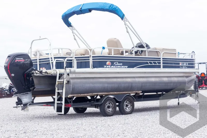 Slide: The Image of 2020 Sun Tracker Fishin' Barge 22 DLX pontoon boat on trailer, side view. - 16