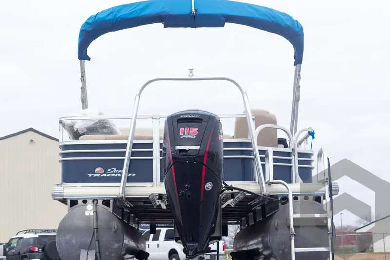 Slide: The Image of 2020 Sun Tracker Fishin' Barge 22 DLX pontoon boat with blue canopy and outboard motor. - 17