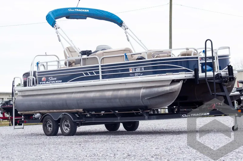 Slide: The Image of 2020 Sun Tracker Fishin' Barge 22 DLX pontoon boat on trailer, blue canopy. - 3