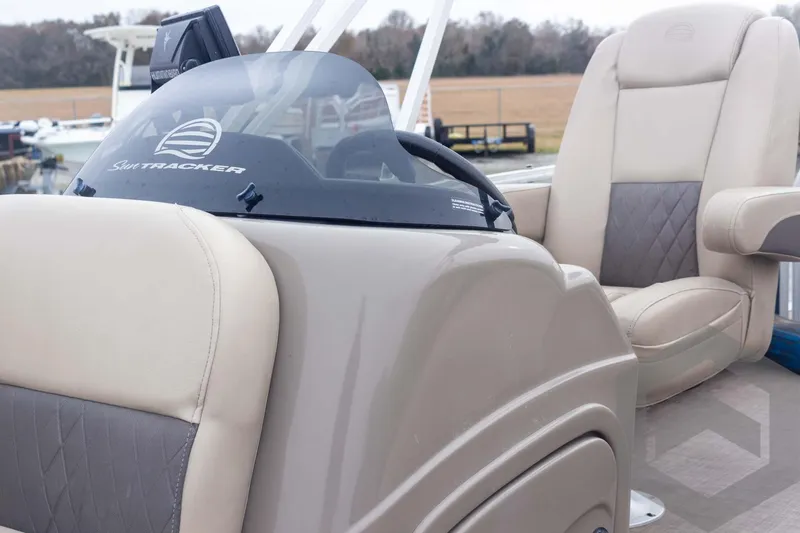 Slide: The Image of 2020 Sun Tracker Fishin' Barge 22 DLX interior with beige seating and console. - 38