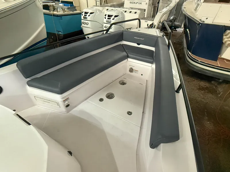 Slide: The Image of 2021 Axopar 28 CABIN boat interior with cushioned seating in a showroom. - 11
