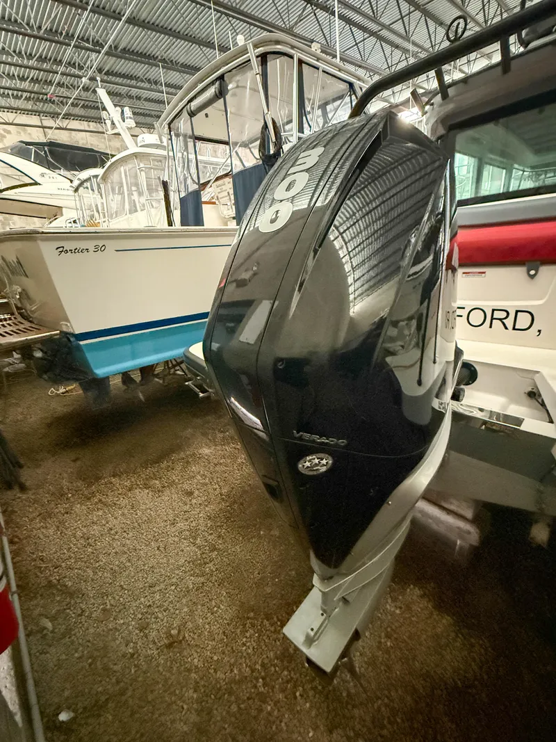 Slide: The Image of 2021 Axopar 28 CABIN with powerful outboard motor in a boat storage facility. - 19
