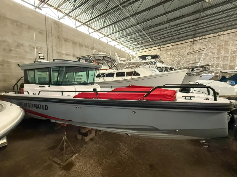 Slide: The Image of 2021 Axopar 28 CABIN boat in storage, featuring a sleek design and red cover. - 2