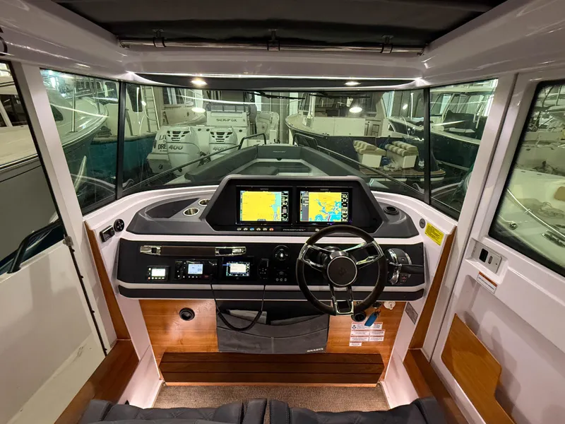 Slide: The Image of Interior view of 2021 Axopar 28 CABIN boat cockpit with navigation screens and steering wheel. - 4