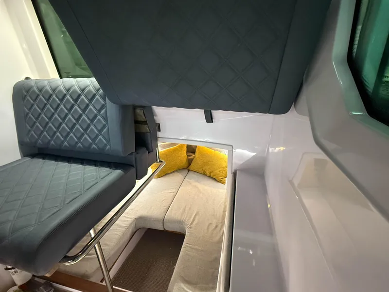 Slide: The Image of Interior of 2021 Axopar 28 CABIN with quilted seating and cozy sleeping area. - 8