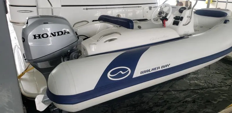Slide: The Image of 2021 Walker Bay Generation 360 DLX boat with Honda outboard motor in docked position. - 12