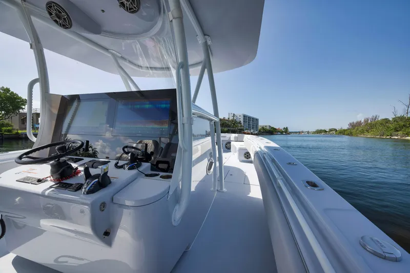 Slide: The Image of 2025 Contender 44 ST boat on a serene waterway, showcasing sleek design and advanced controls. - 21