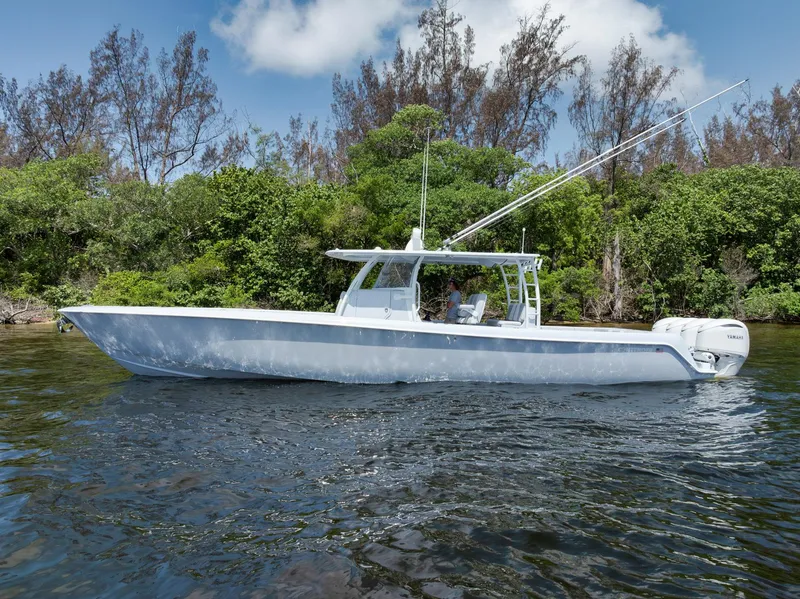 Slide: The Image of 2025 Contender 44 ST boat on water, surrounded by lush greenery and clear blue sky. - 5