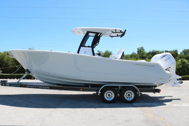 Slide: The Image of 2025 Sportsman Open 252 Center Console boat on trailer, side view, outdoors. - 1