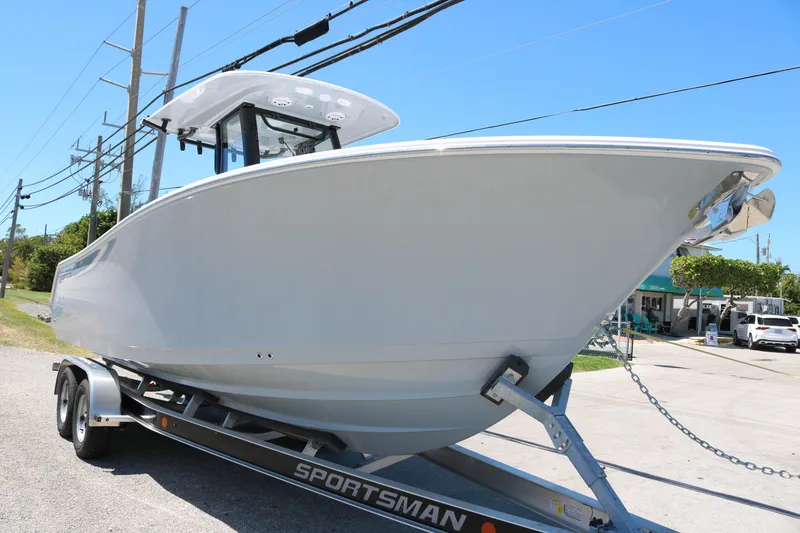Slide: The Image of 2025 Sportsman Open 252 Center Console boat on trailer, side view, sunny day. - 2
