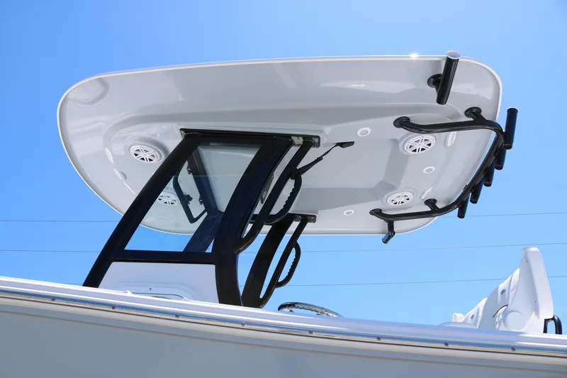 Slide: The Image of 2025 Sportsman Open 252 Center Console boat with T-top and rod holders under clear sky. - 5