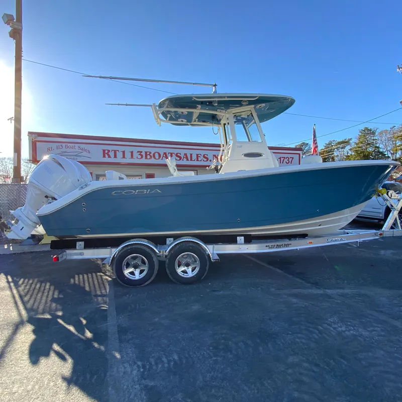 The Image of 2025 Cobia 240 Center Console boat on trailer at dealership. - 1