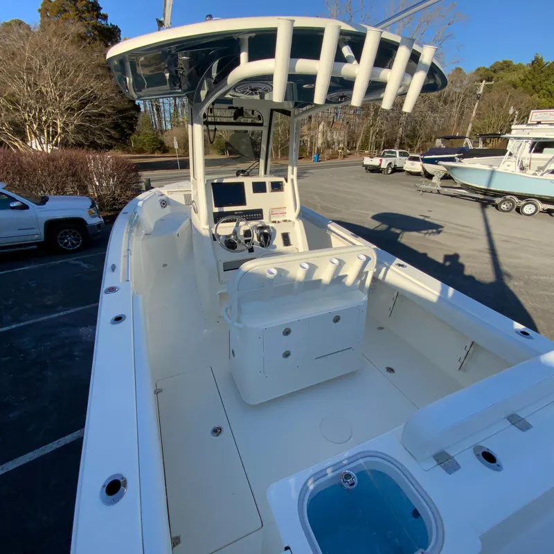 Slide: The Image of 2025 Cobia 240 Center Console boat in a parking lot, showcasing spacious deck and controls. - 11