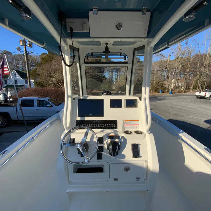 Slide: The Image of 2025 Cobia 240 Center Console boat dashboard with steering wheel and controls. - 12