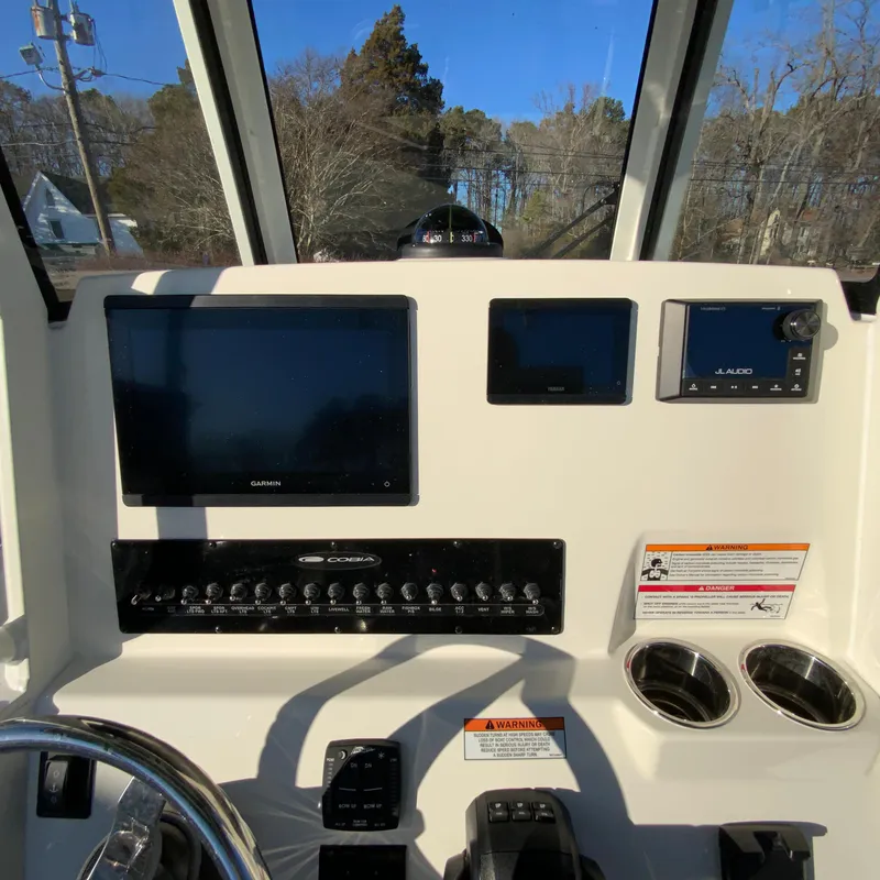 Slide: The Image of 2025 Cobia 240 Center Console dashboard with navigation screens and controls. - 13