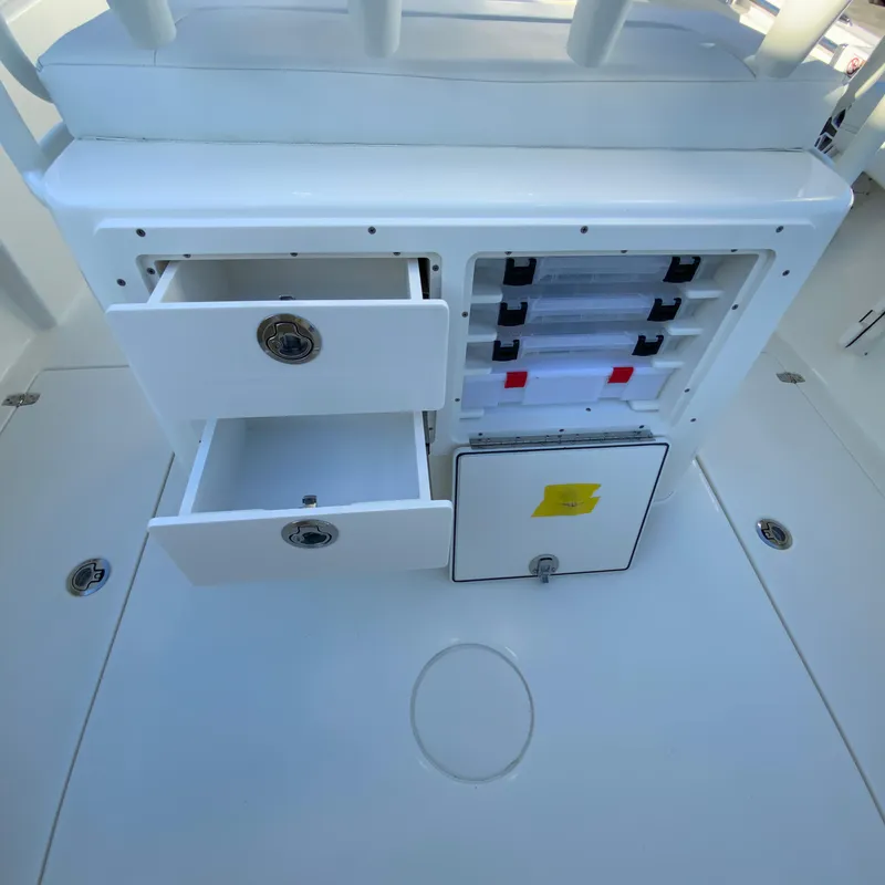 Slide: The Image of 2025 Cobia 240 Center Console storage compartments with open drawers and tackle boxes. - 17
